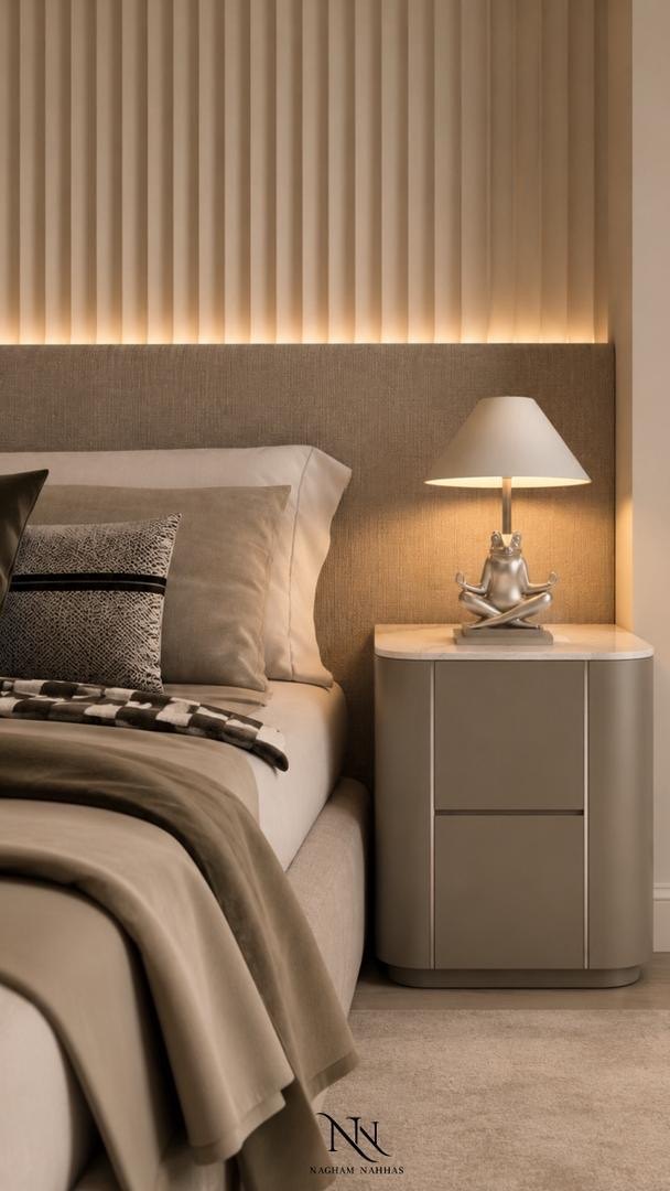 Bedside table with a silver frog lamp in front of a fluted headboard wall